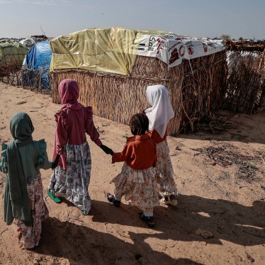 Sudanese girls who fled the conflict in Sudan's Darfur region, walk beside makeshift shelters in Adre, Chad, July 29, 2023.